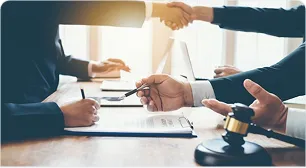 Two parties shaking hands beside a gavel